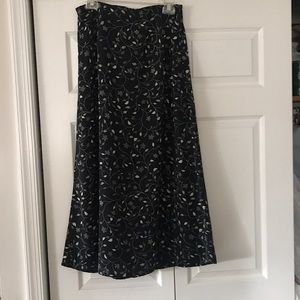 Ladies skirt. Rests mid calf. Black with green flowers. Size large.
